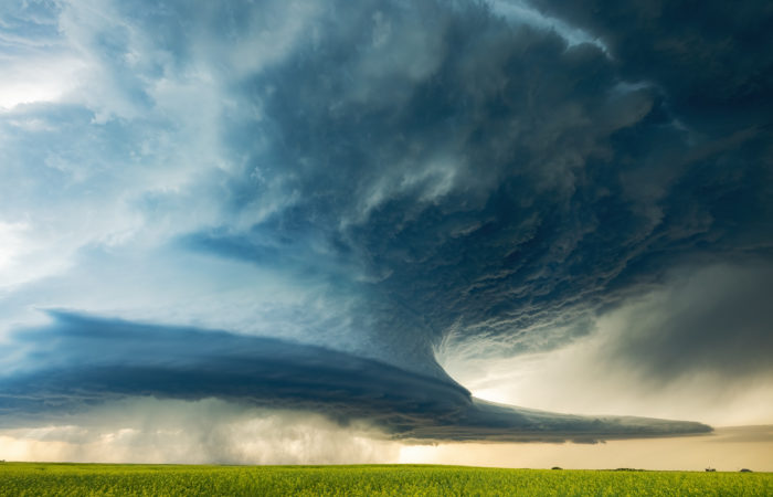 large supercell thunderstorm over a canola field in saskatchewan