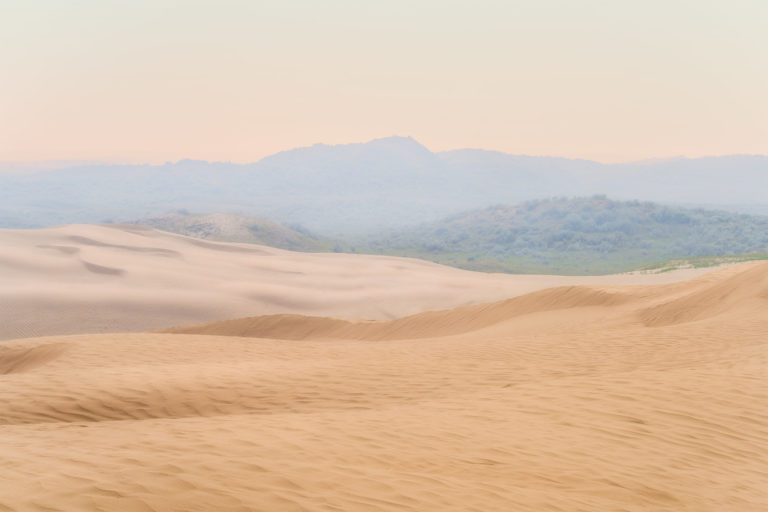 a landscape photograph of the Great Sandhills in saskatchewan featuring sand dunes and wildfire smoke